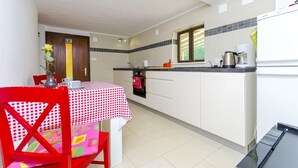 Eine Küche mit Esstisch, Stühlen und einem Kühlschrank.