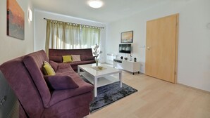 Un salon avec un canapé, une table basse et un téléviseur.