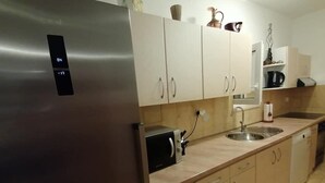 Una cocina moderna con electrodomésticos de acero inoxidable, armarios de madera y lavavajillas integrado.