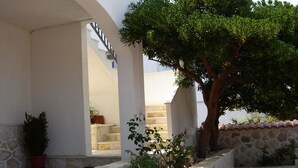 A building with a stone facade, a tree, and a staircase leading to an upper level. - Apartments Hani (Postira)