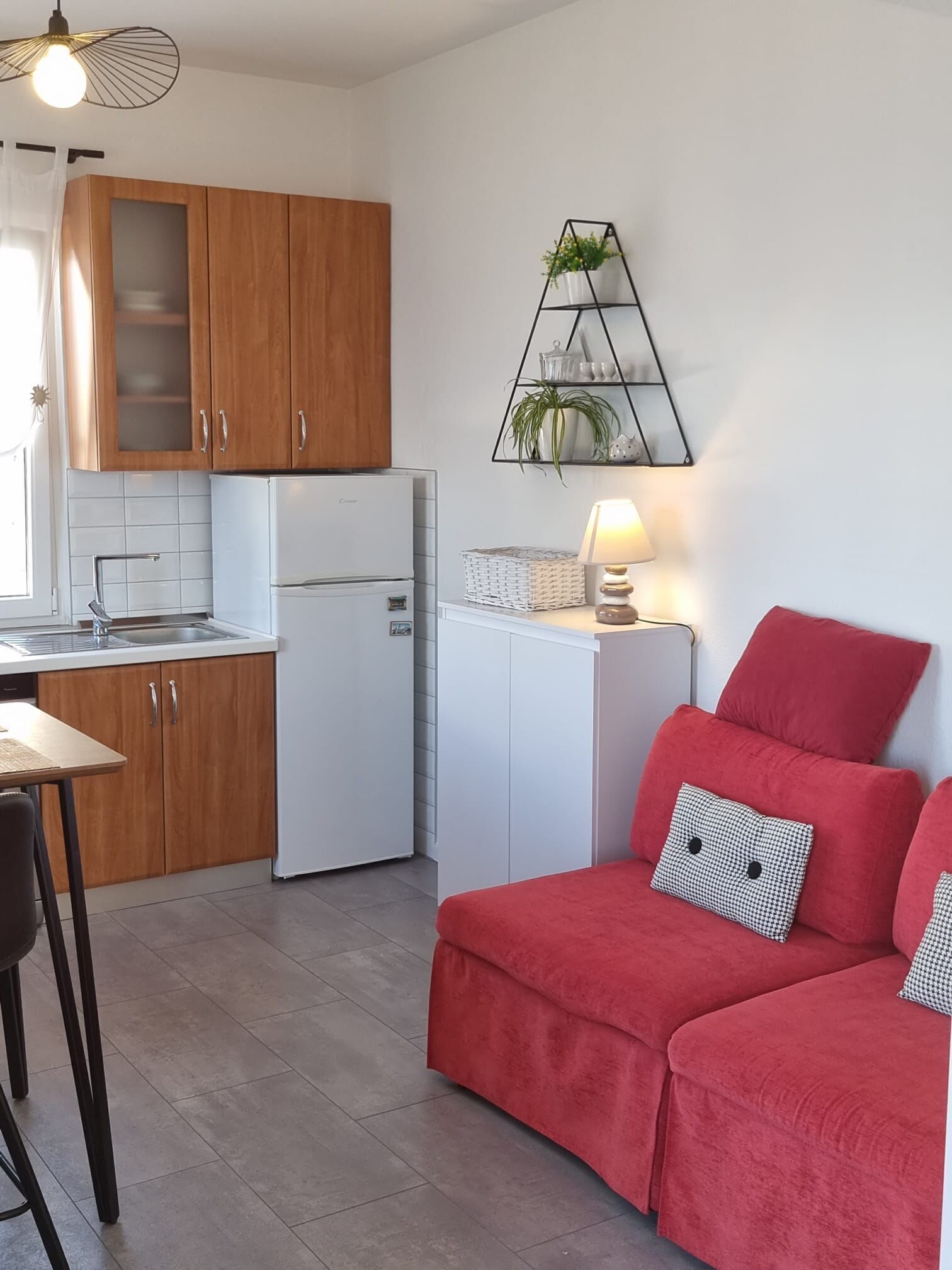 A compact kitchen with wooden cabinets, a white refrigerator, and a dining area with a table and chairs.