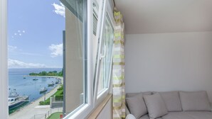 Una habitación con un amplio ventanal con vistas a un puerto deportivo lleno de barcos.