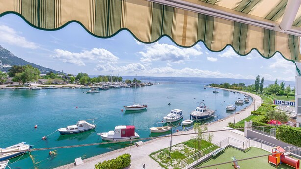 Un puerto deportivo con barcos amarrados, cielo despejado y vistas del paisaje circundante.