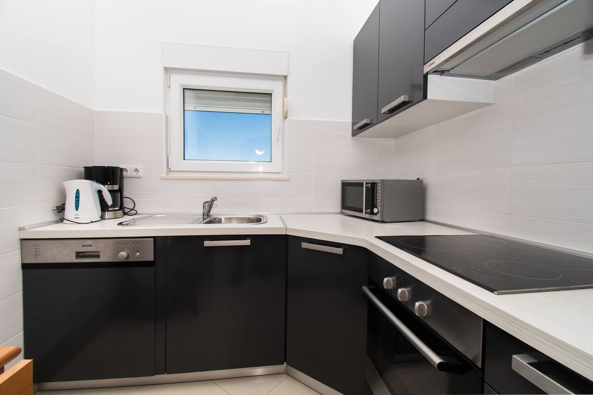 A modern kitchen with a dishwasher, microwave, and stove.
