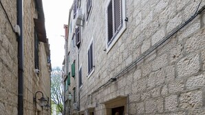 Un estrecho callejón empedrado flanqueado por edificios de arquitectura tradicional, con puertas y ventanas visibles.