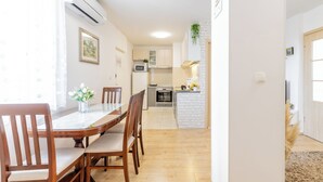 Una cocina moderna con armarios blancos, microondas y una pequeña isla con pileta.