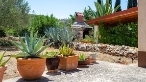 Un jardin agrémenté de plantes en pot et d’une structure en pierre.