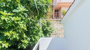 Un balcón con vistas a un muro de piedra y un edificio con balcones.
