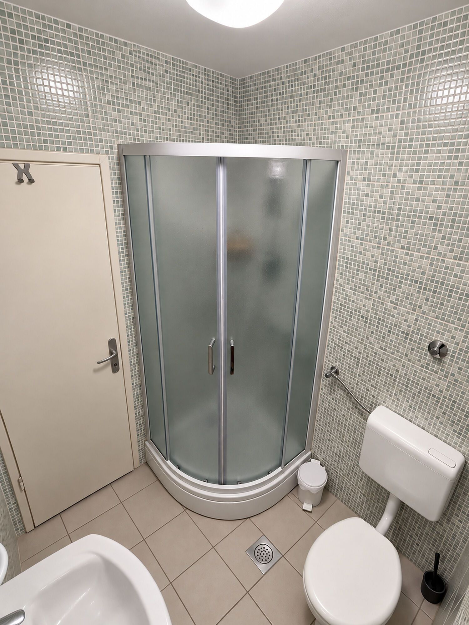 A bathroom with a glass-enclosed shower, a toilet, and a bathtub.