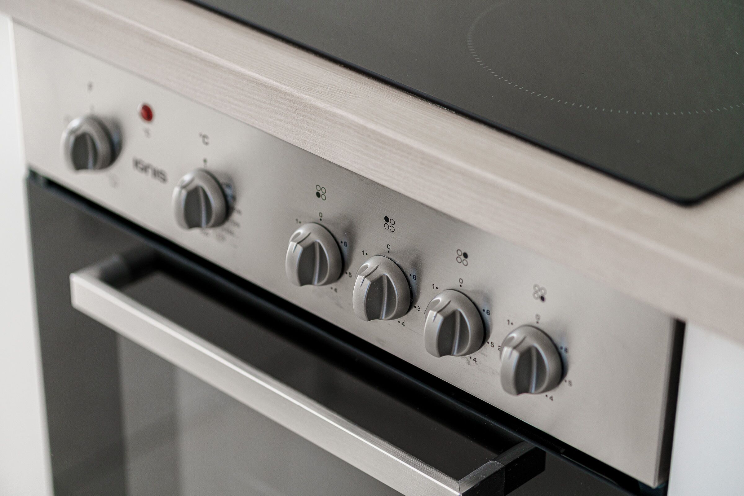 Een keuken met een roestvrijstalen oven en een inbouw kookplaat.