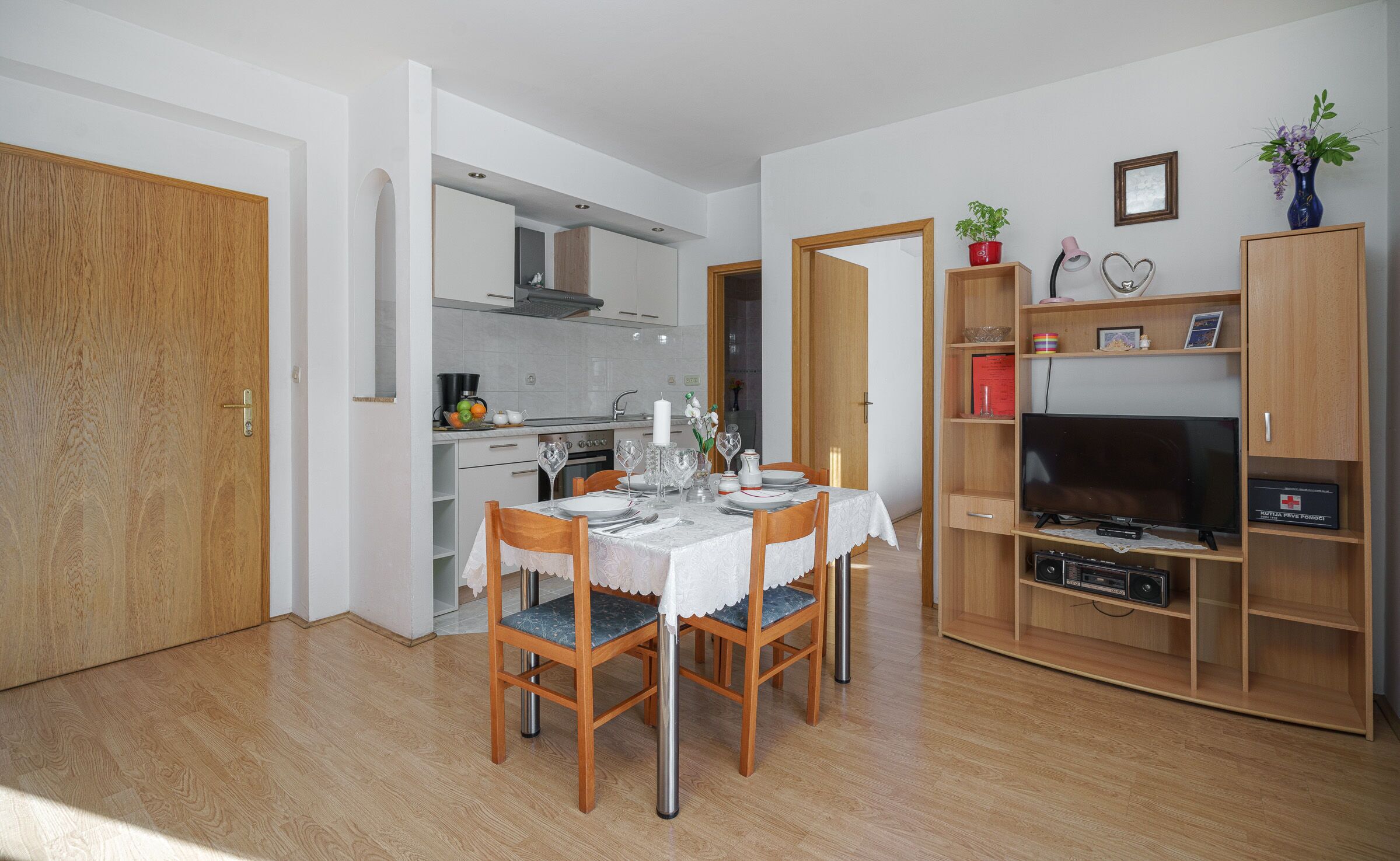 A compact living space with a dining area, kitchen, and entertainment unit.