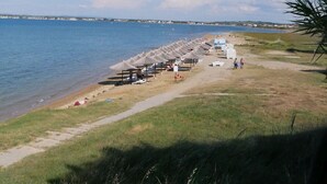 A beach with umbrellas and a path leading to the water. - Apartments Rote Rosen (Sabunike)