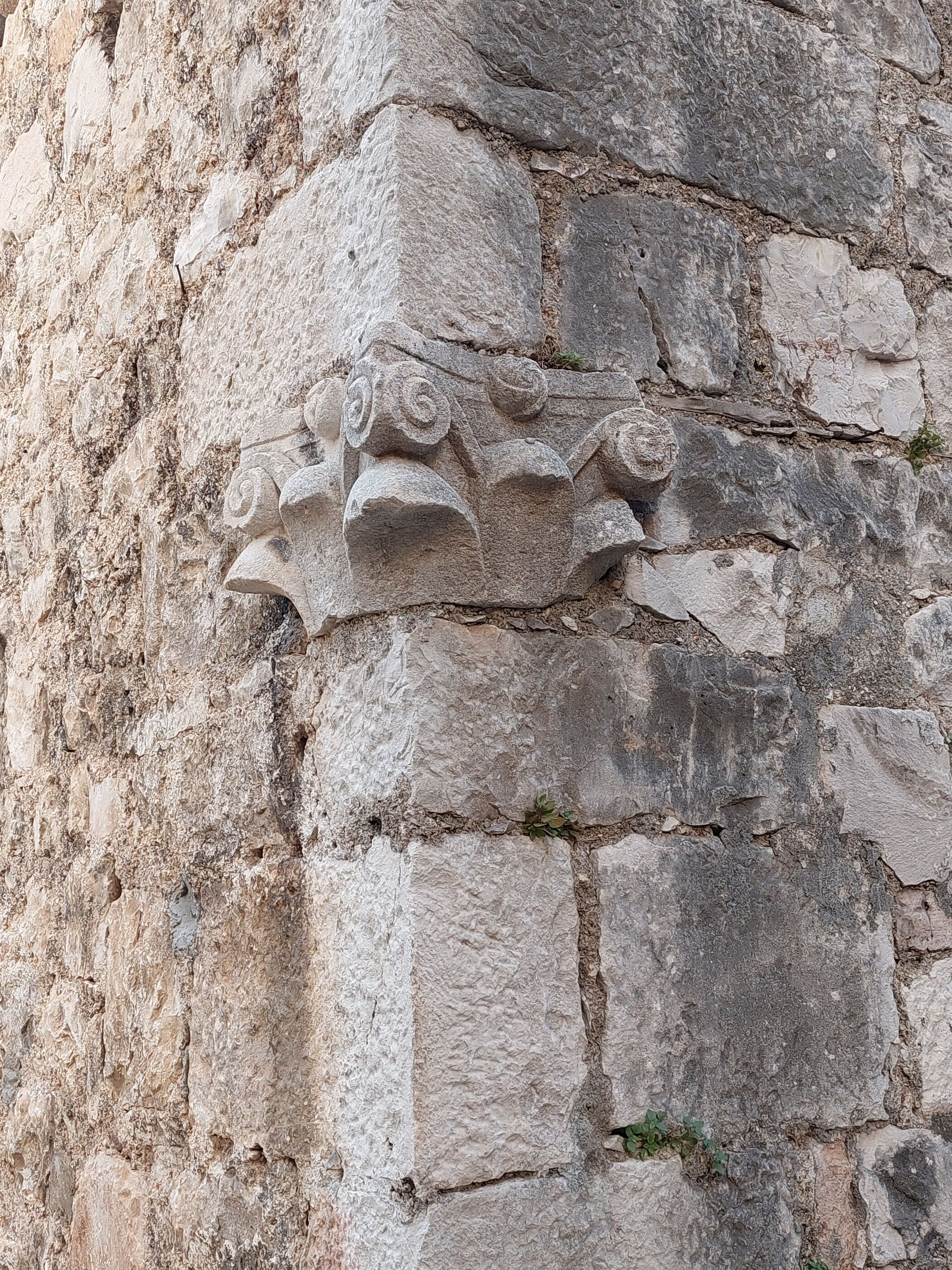 A stone wall with carved floral patterns.