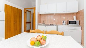A compact kitchen with white cabinets, a microwave, and a sink.