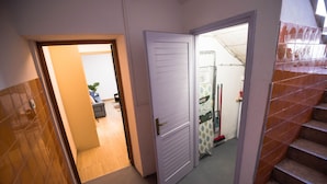 A hallway with a closed door, a staircase, and a glimpse of a bathroom with a shower and a toilet. - Apartment N D (Sibenik)