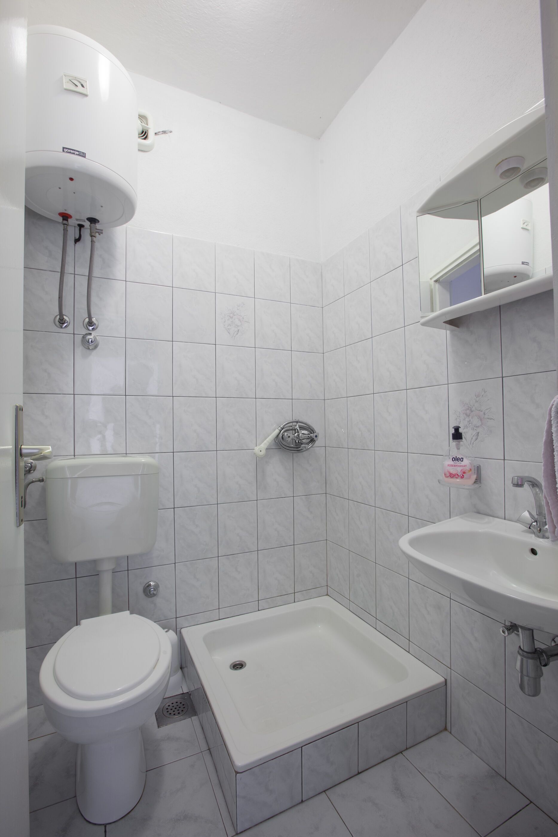 A modern bathroom with a toilet, sink, and shower.