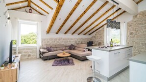 Eine moderne Küche mit einer Steinwand, Holzbalken und einer großen Kochinsel.