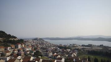 A coastal town with a view of the sea and distant mountains.