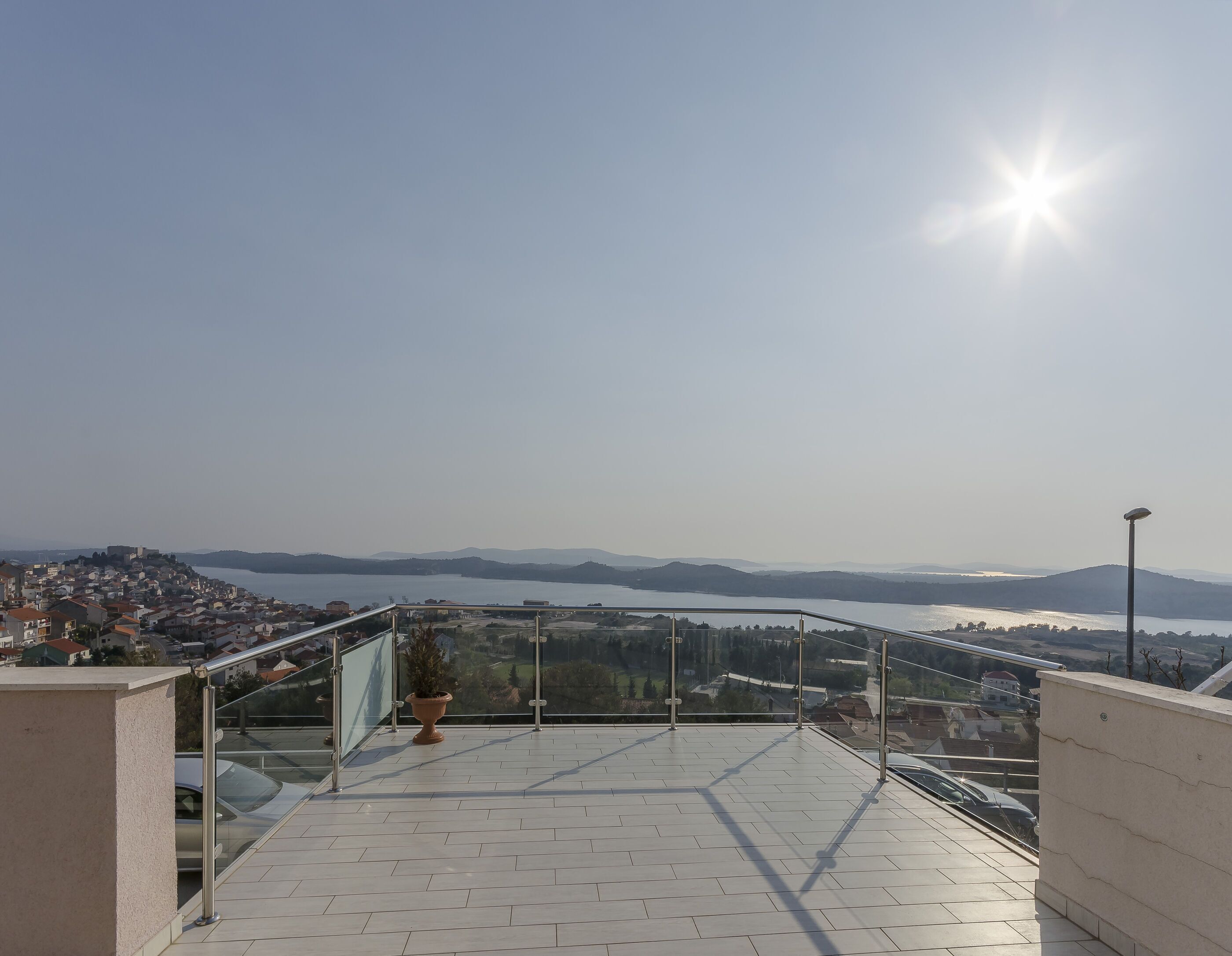A terrace with a view of a lake and distant mountains.