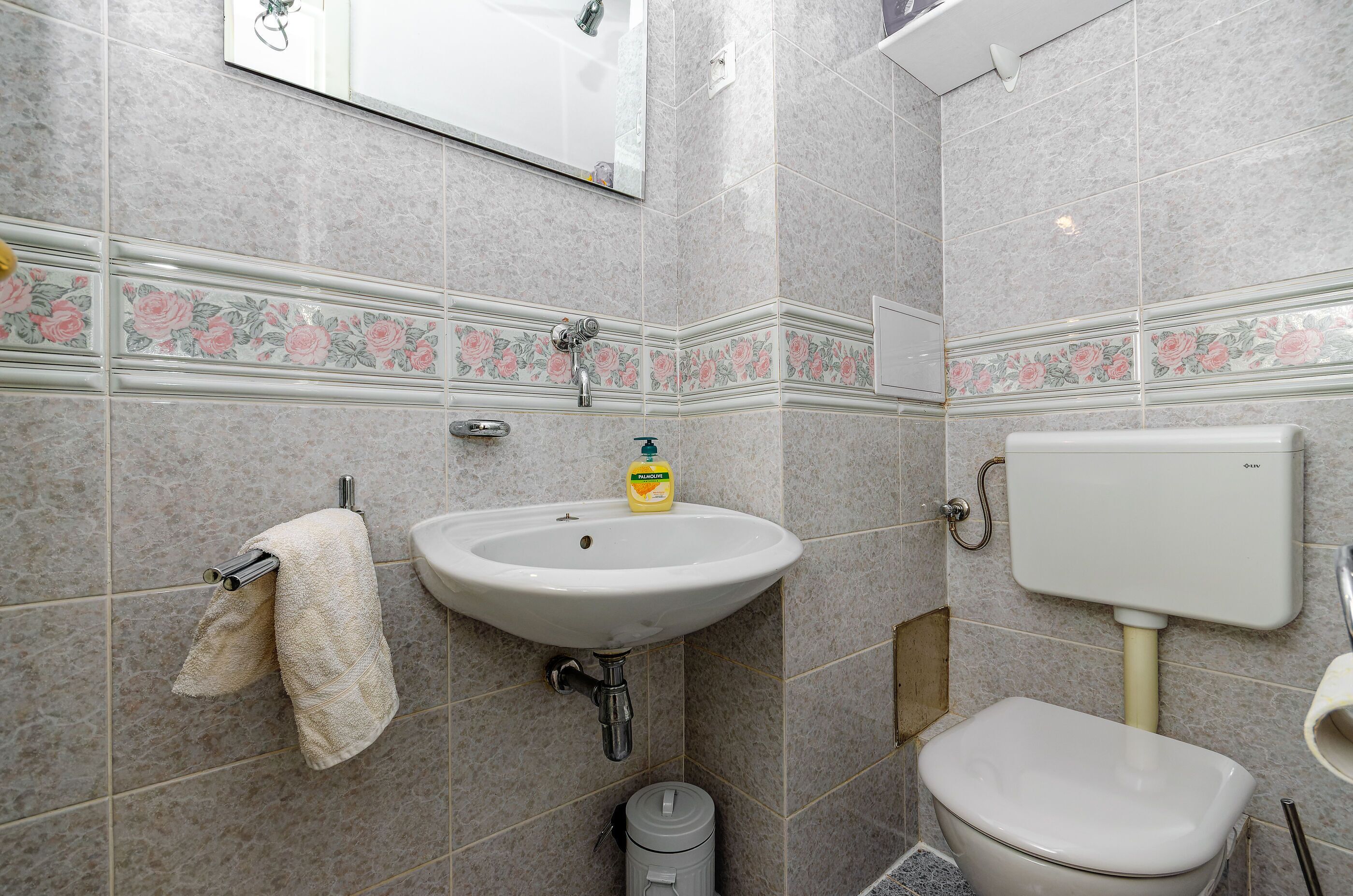 Un baño con lavabo, inodoro y espejo.