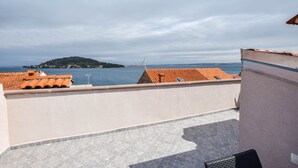 En takterrass med utsikt över havet och en avlägsen ö.