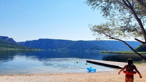 A pebbled beach with a lake and mountains in the background. - Villa Laurel (Rupe)