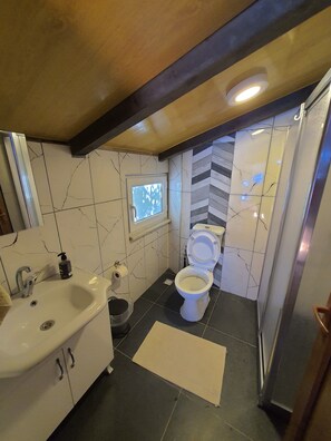 A bathroom with a sink, toilet, and window. - Çeşmeönü Bungalov (Persembe)