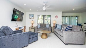 A modern living room with grey sofas, a wooden coffee table, and a ceiling fan. - Blind Pass E103 - over 1500 sq ft ~ 8 person occupancy (Sanibel)