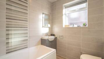 Bathtub, hair dryer, towels, shampoo