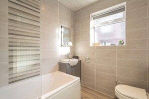 Een bad, een haardroger, handdoeken, shampoo