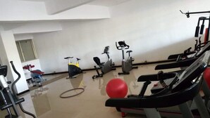 Een sportschool met loopbanden, hometrainers en fitnessballen.