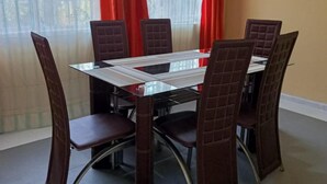 A dining area with a rectangular table and six upholstered chairs with metal legs. - Stay.Plus Karen Private House (Nairobi)