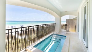 A balcony with a pool overlooking a beach. - Kamps Baai, Beachfront Home, Golf Cart, 2 Pools (Miramar Beach)
