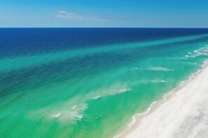 An aerial view of a beach with clear turquoise waters and a sandy shoreline. - Kamps Baai, Beachfront Home, Golf Cart, 2 Pools (Miramar Beach)