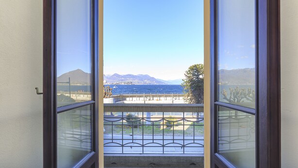 Uma varanda com vista para o mar, montanhas e uma ponte.