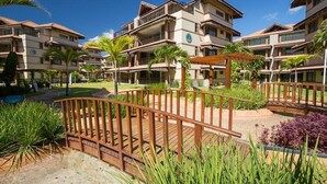 A resort with multiple-story buildings, outdoor patios, and palm trees. - Aquiraz Manhattan Riviera (Aquiraz)