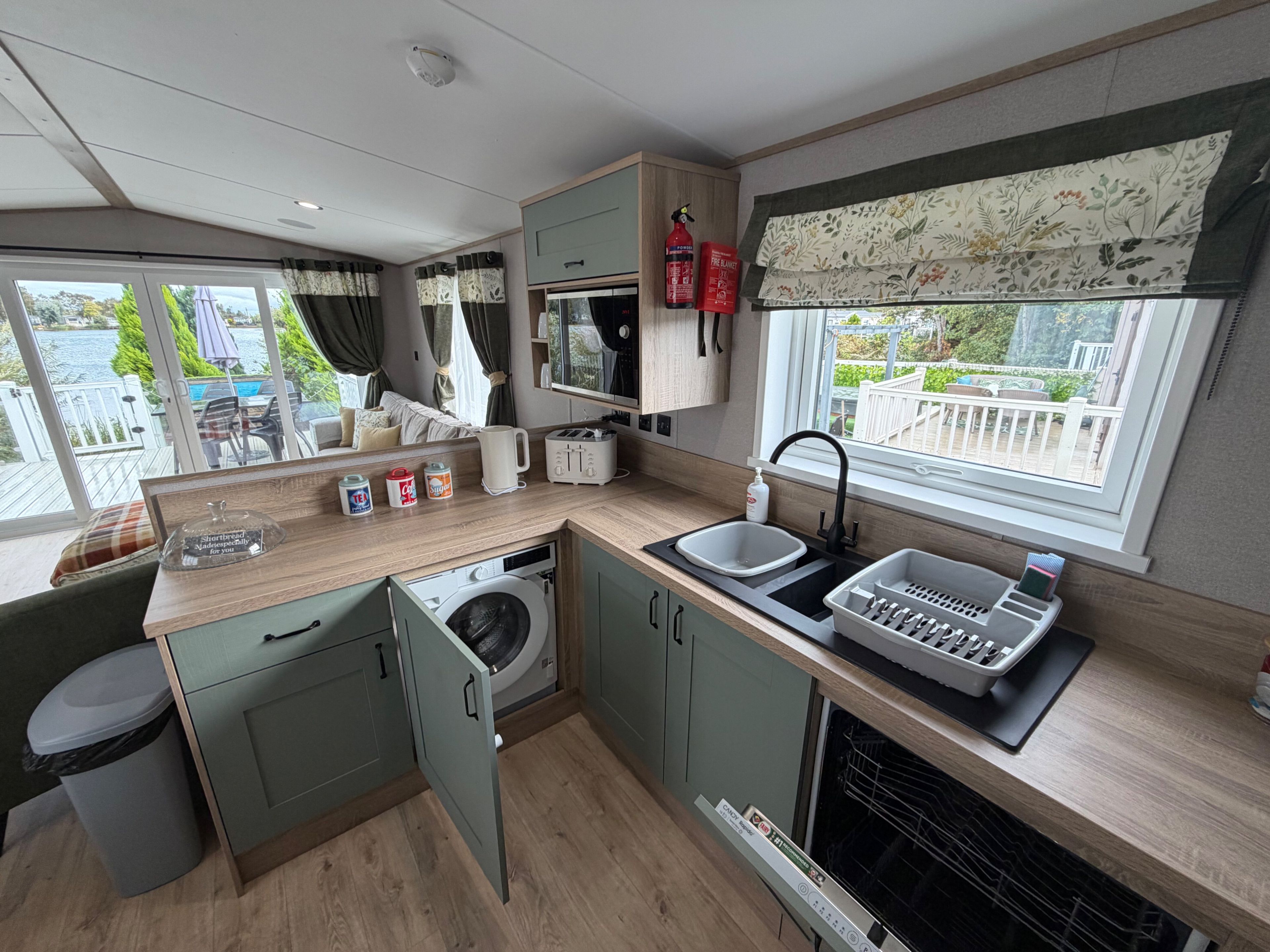 Una kitchenette compacta con lavadora, pileta y ventana con vista al exterior.