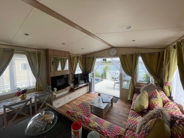 A cozy living room with a sofa, TV, and dining area.