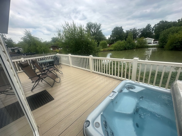 Relax on the deck overlooking the river with a hot tub and scenic views of the lush landscape.