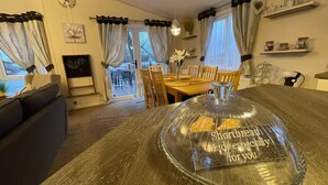 Ein gemütlicher Essbereich mit einem Holztisch, Stühlen und einer Glaskuppel mit Text.