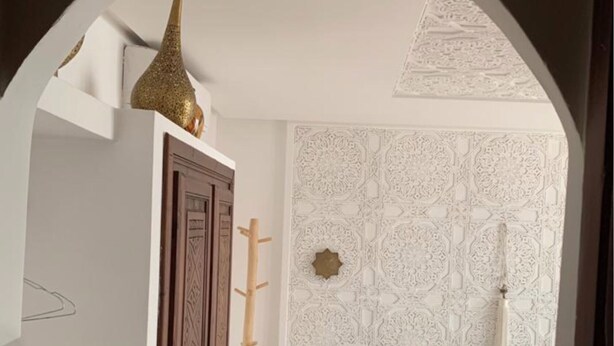 Une chambre à coucher comprenant un lit, une armoire, une table de chevet et un mur décoratif.