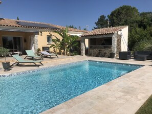 A swimming pool with lounge chairs, a barbecue area, and a stone-tiled patio. - T2 apartment 30 minutes from the beach (Saussines)