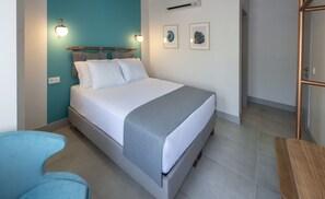 Un dormitorio moderno con una cama, una mesita de noche, una silla y una obra de arte en la pared.