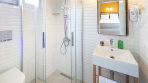 A modern bathroom with a glass-enclosed shower, a white sink, and a mirror above it. - Meraki Bozcaada (Bozcaada)