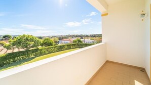 Un balcon offrant une vue dégagée sur un quartier résidentiel, avec ses maisons et sa verdure.
