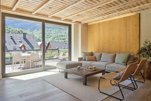 A modern living room with a sofa, chairs, a coffee table, and a large window offering a view of a mountainous landscape. - Casa Garona by FeelFree Rentals (Vielha)