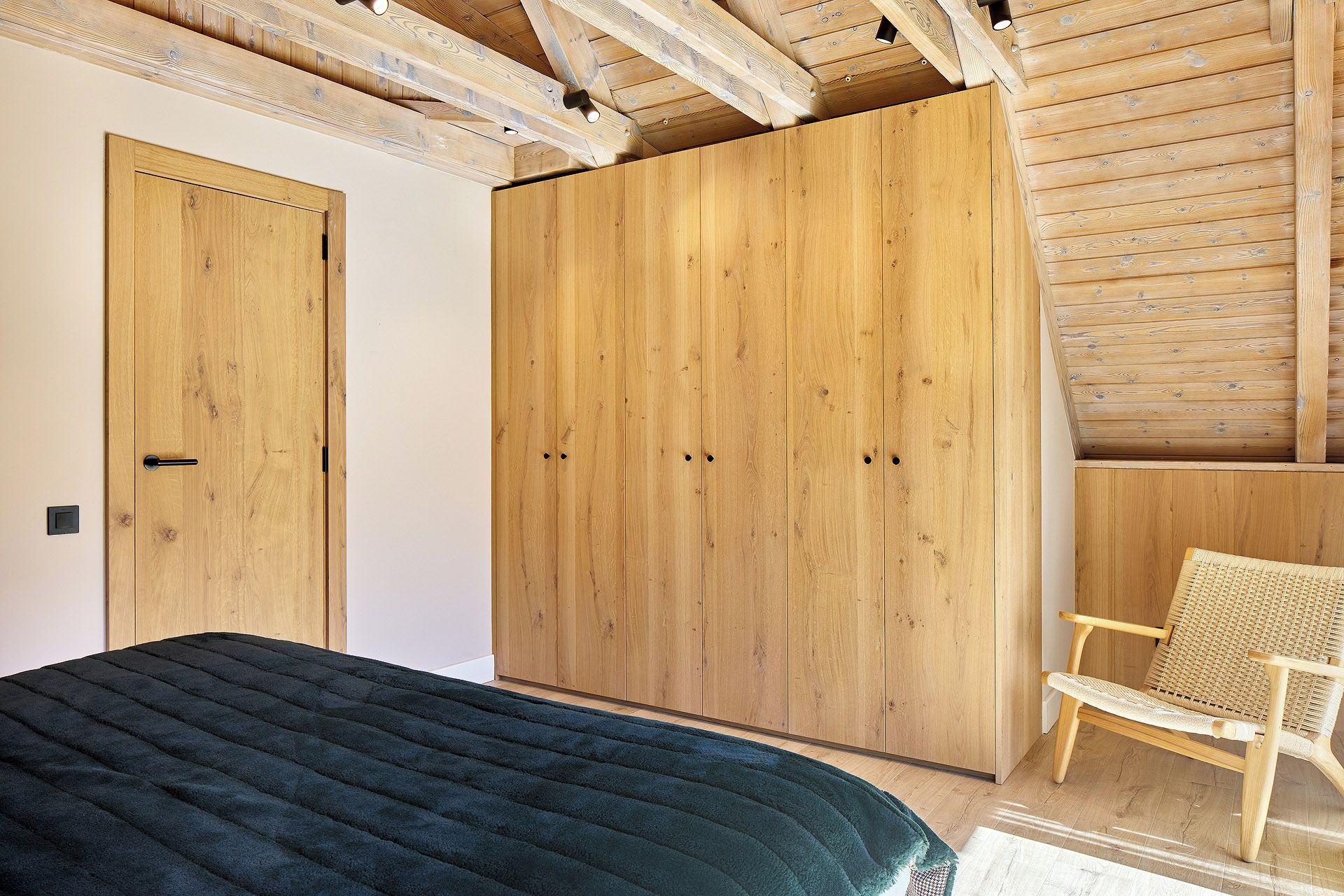Ein Schlafzimmer mit Bett, Kleiderschrank und Stuhl.