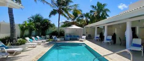 Een buitenzwembad en ligstoelen