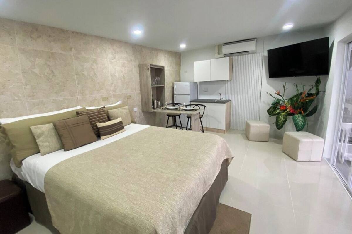 Een moderne hotelkamer met een groot bed, een bureau en een televisie.