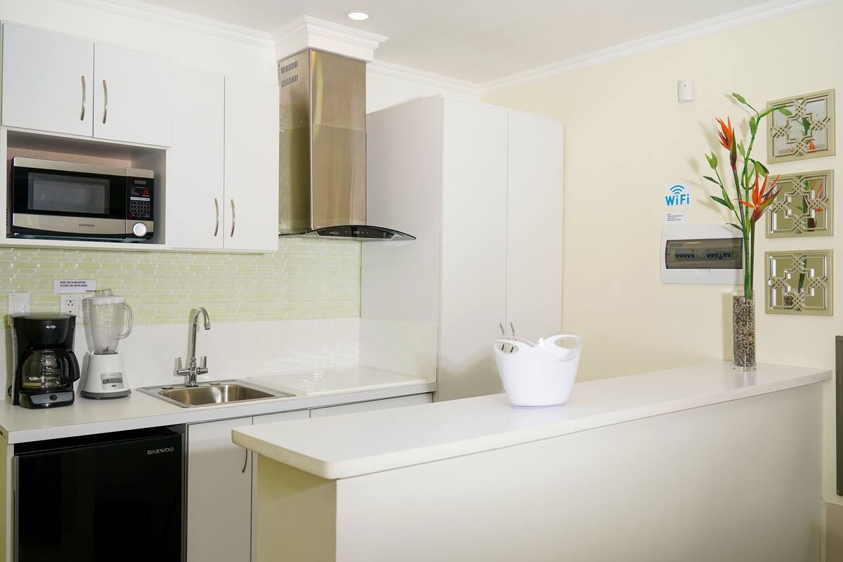 Een moderne keuken met een magnetron, koffiezetapparaat en vaatwasser.